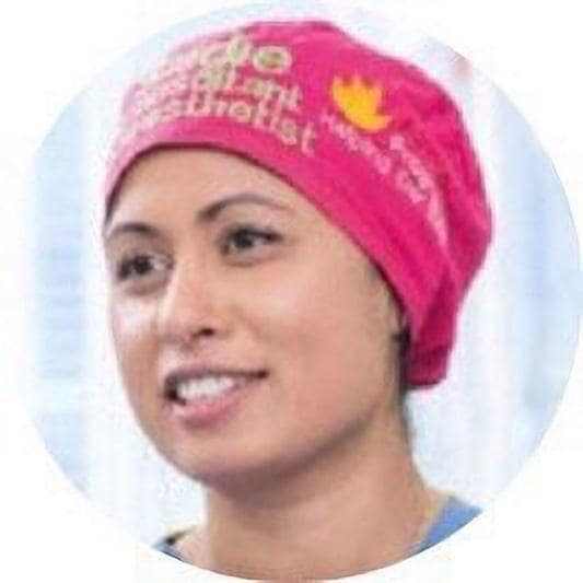 A person wearing a pink head wrap

Description automatically generated